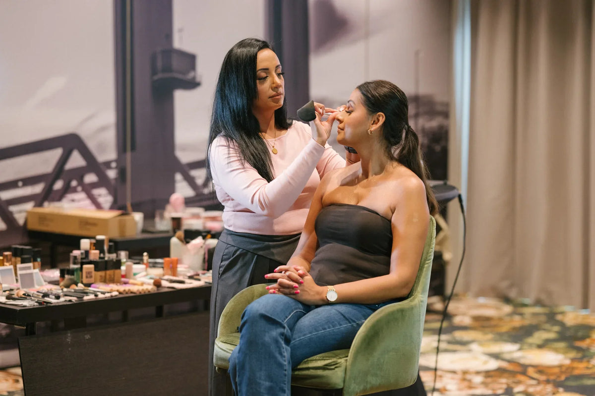 Make-up artist demonstreert een techniek op een model tijdens de Everyday Glam Workshop