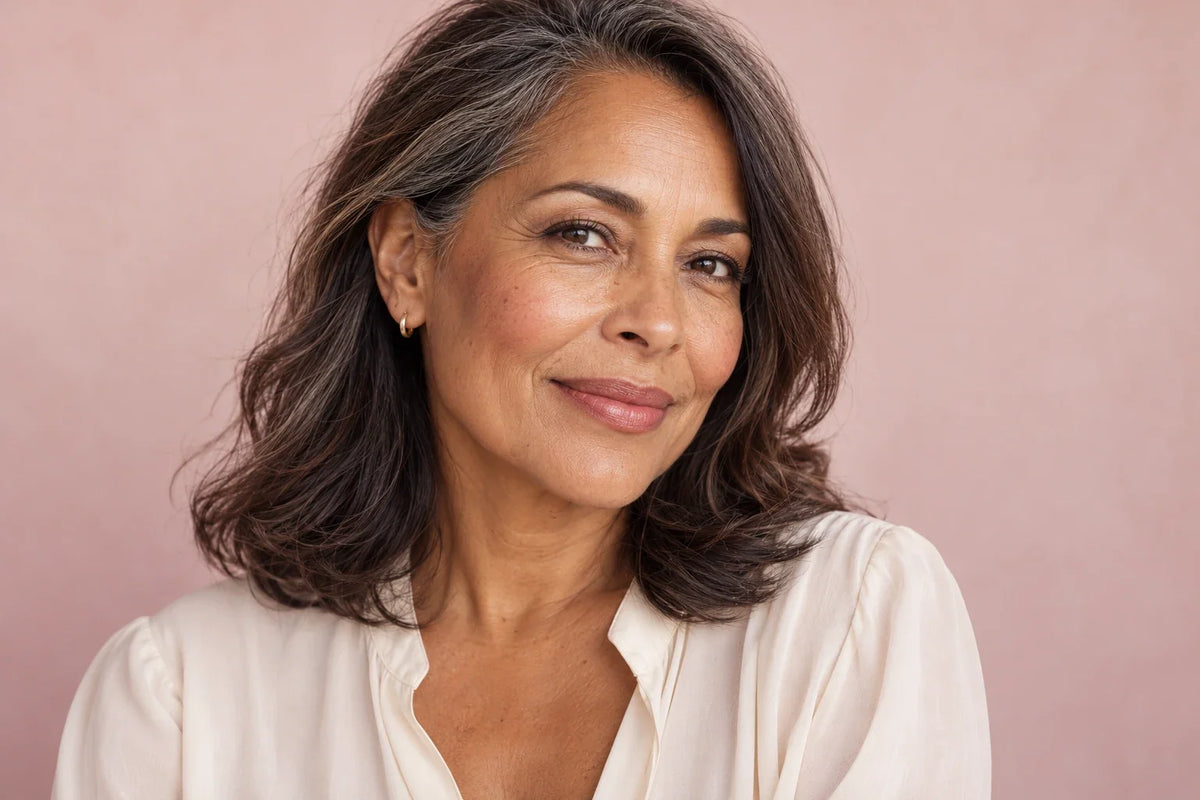 Vrouw met natuurlijke huidtextuur, zachtroze blush en een frisse, subtiele make-uplook.