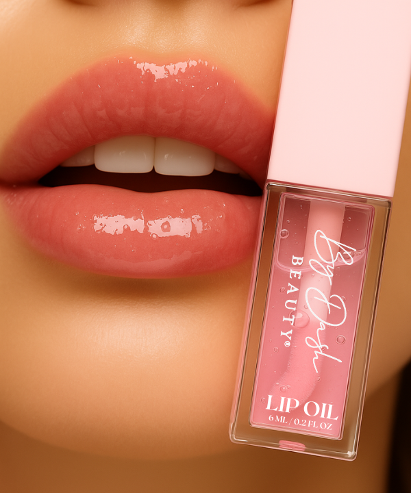 Glanzende lippen naast een flesje Ambitious Lip Oil van By Dash Beauty