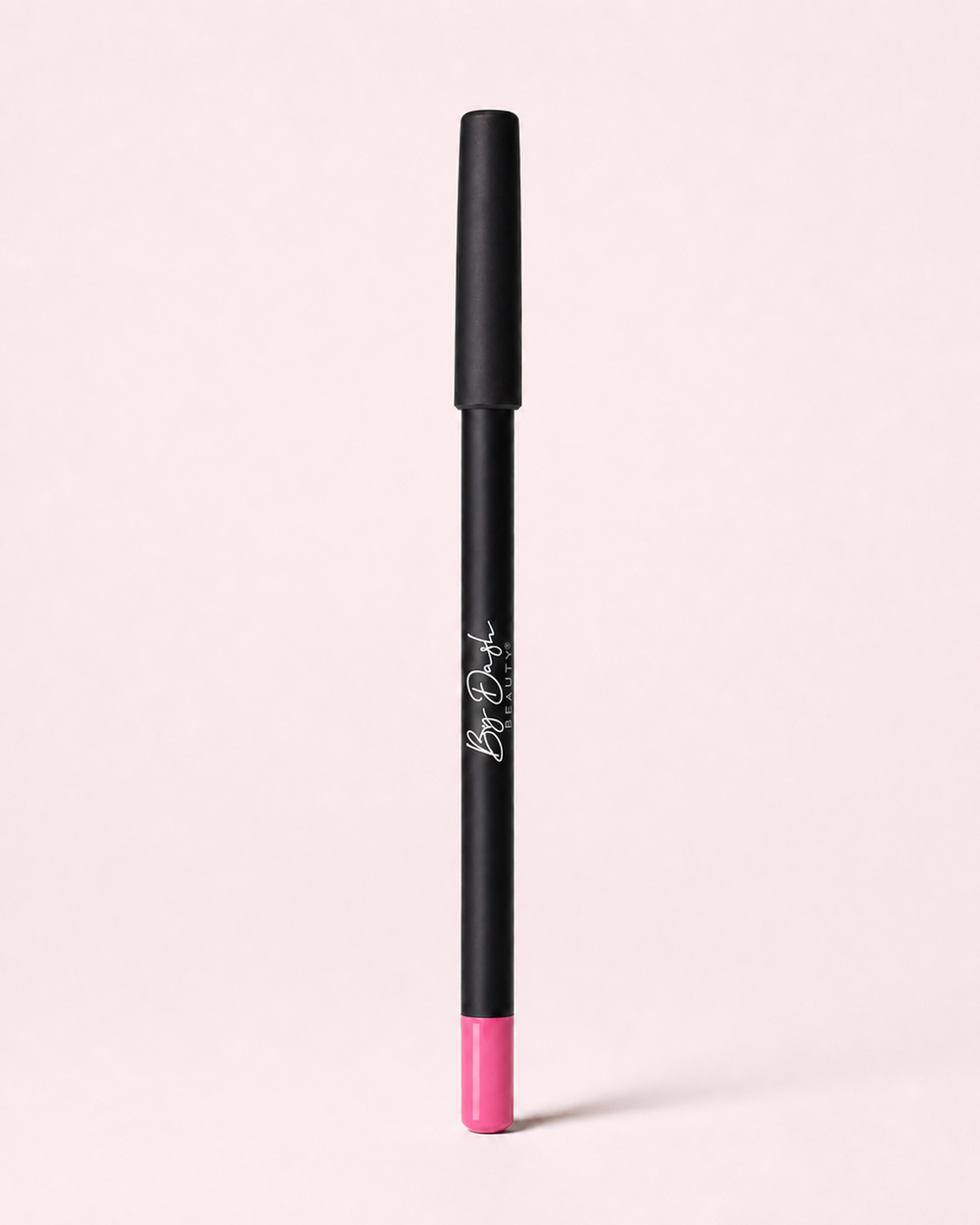 Rose-lipliner van By Dash Beauty met zwarte huls en roze uiteinde op een lichtroze achtergrond.