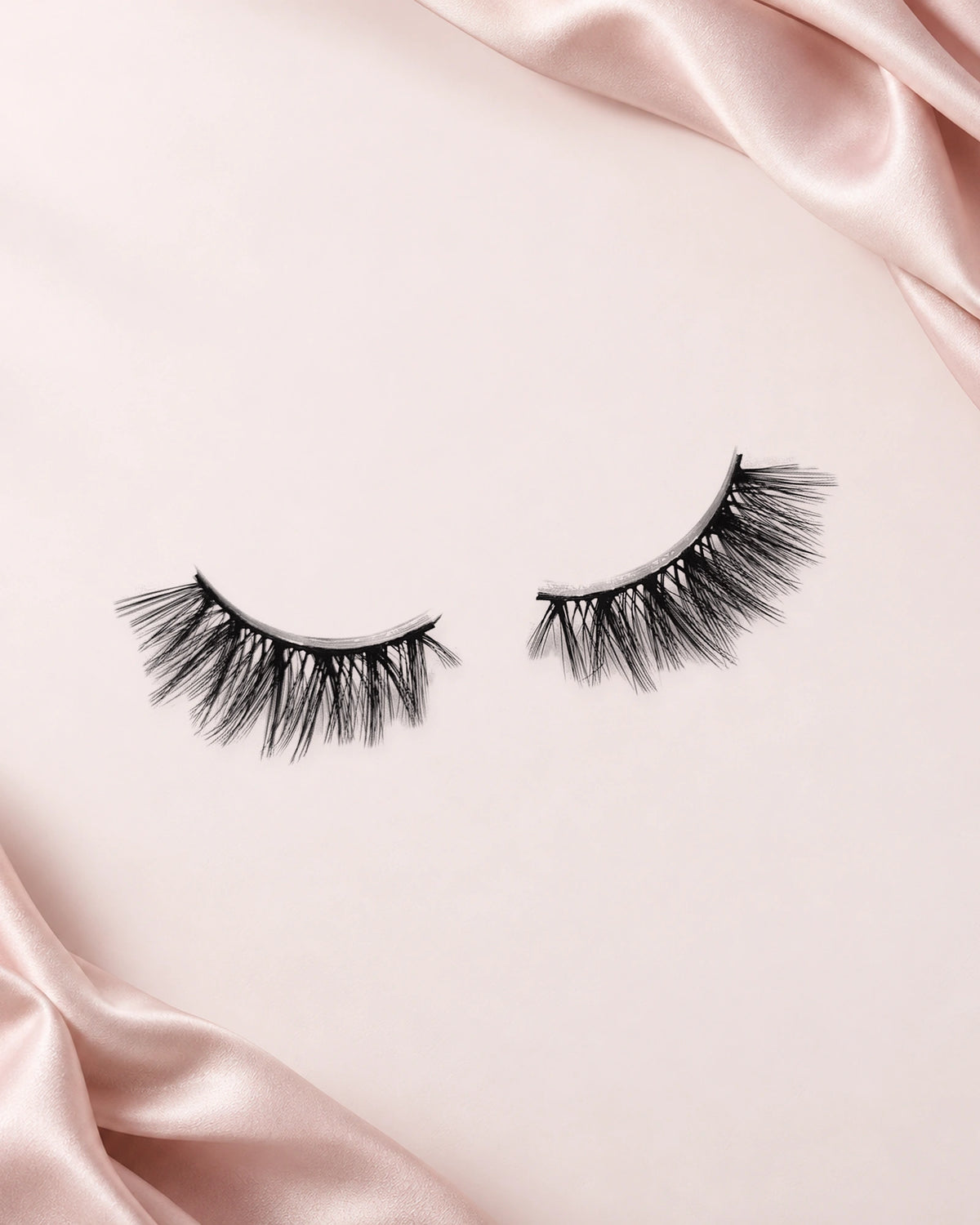 Heartbreaker halve wimpers van By Dash Beauty op een lichtroze achtergrond met satijn
